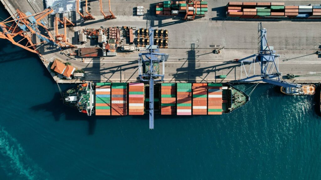 drönarfoto på hamn med containerfartyg